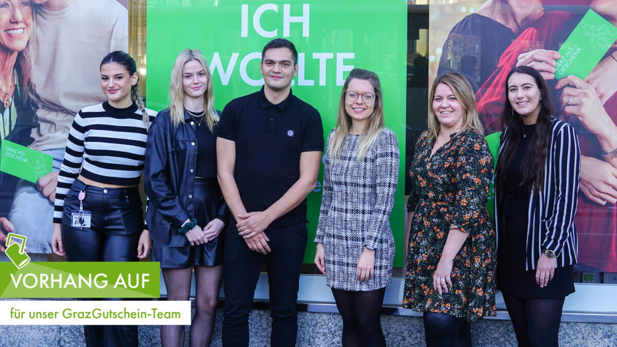 GrazGutschein-Team vor grünem Hintergrund mit Schriftzug „Vorhang auf für unser GrazGutschein-Team“